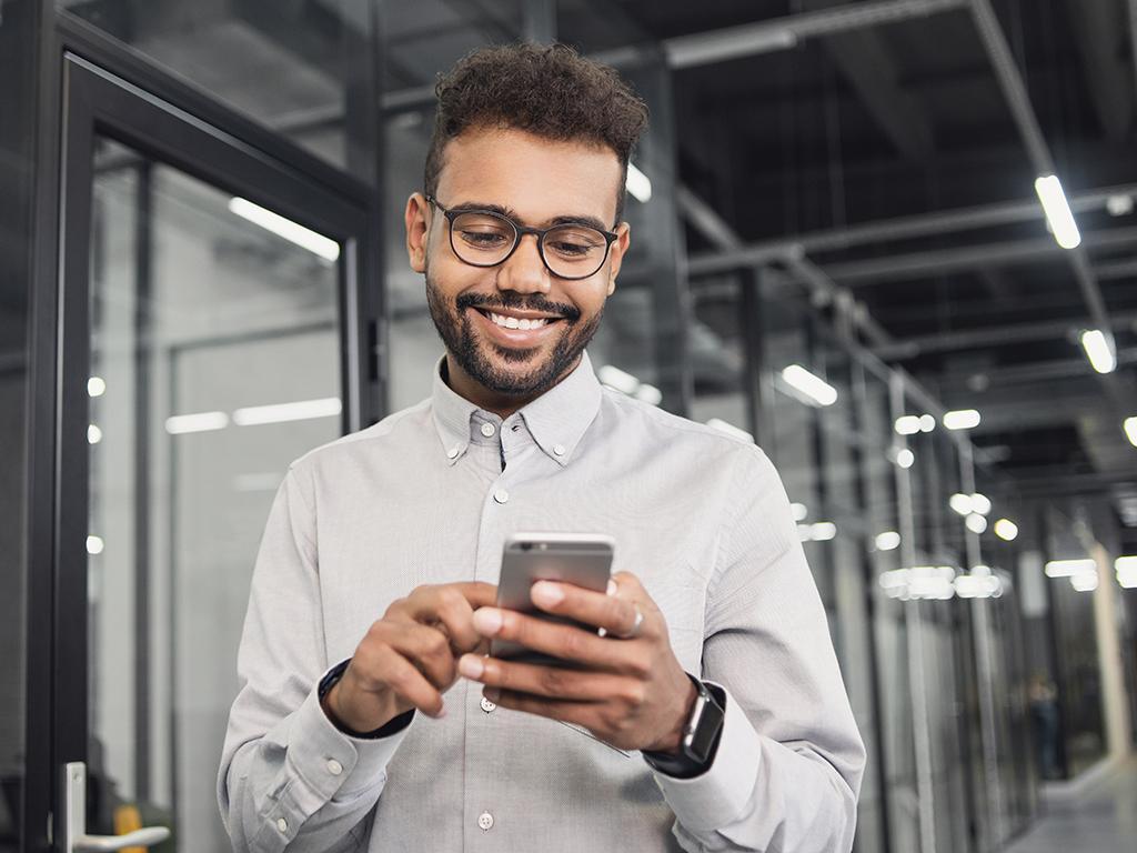 A smiling customer receiving text notifications about vehicle service updates.